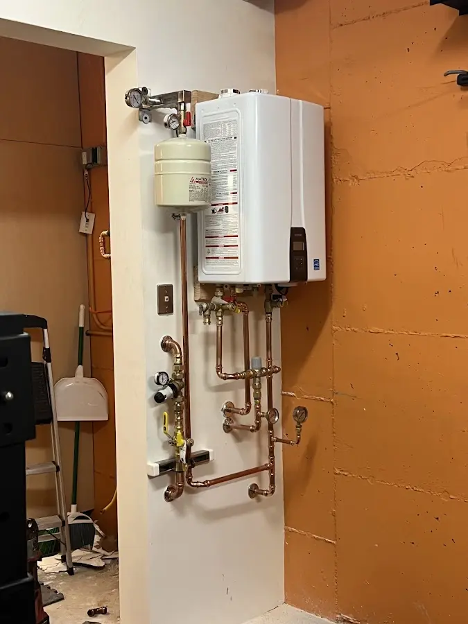 Plumbing technician inspecting water heater connections in Chino Valley